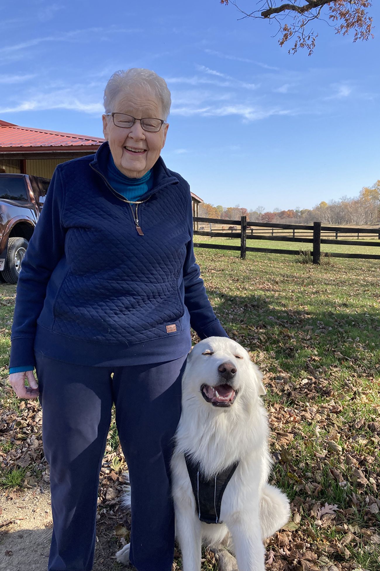 Linda Delene stands next to a white, fluffy dog.