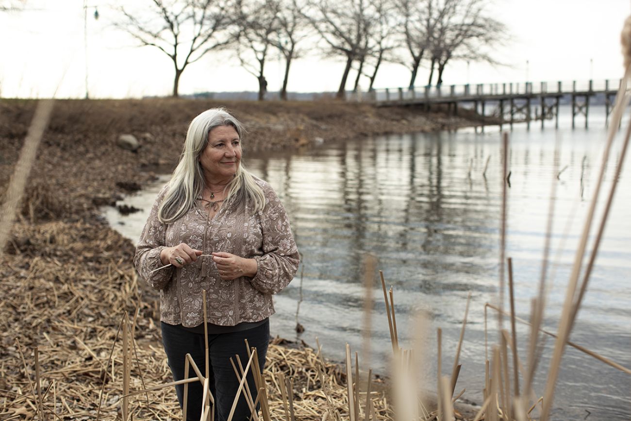 Kathy Evans stands on the shore of Muskegon Lake. 