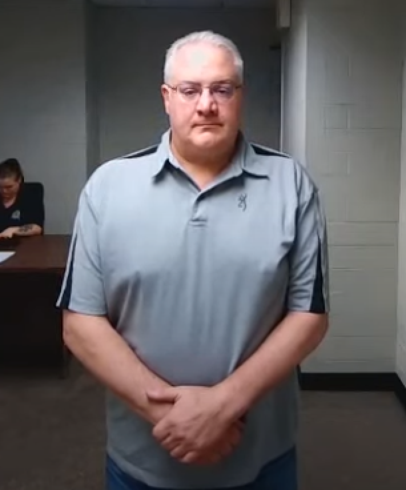 David Coker wears a grey polo. 