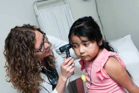A doctor examines a young girl. 