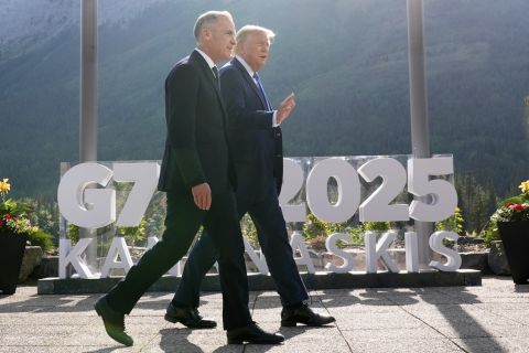 Canada's Prime Minister Mark Carney walks with President Donald Trump.