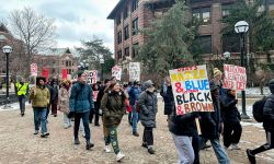 Students marching and carrying pro-DEI sign.